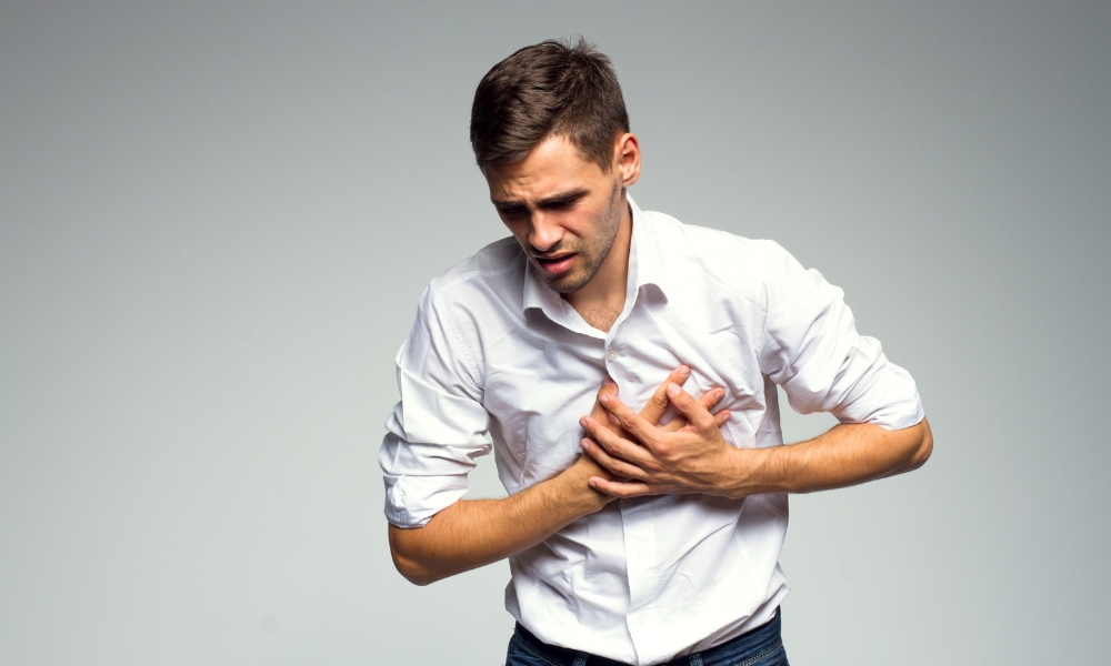 Doctor evaluating a patient experiencing chest pain during a medical consultation
